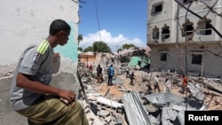 A Somali man watches the damage caused at the scene where a car exploded in the Madina district of Mogadishu, Somalia, May 17, 2017. 