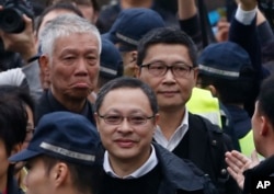 FILE - Three protest leaders, from right, Chan Kin-man, Benny Tai Yiu-ting and Chu Yiu-ming walk towards the police station in Hong Kong as they surrender to police, Dec. 3, 2014.