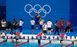 Para atlet berkumpul di kolam renang saat sesi latihan renang di Tokyo Aquatics Center Olimpiade Musim Panas 2020, di Tokyo, Jepang, Rabu, 21 Juli 2021. (Foto AP/Martin Meissner)