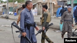 Kurdish fighters guard in the street in the Iraqi town of Qara Tappa north of Baghdad, October 21, 2014.