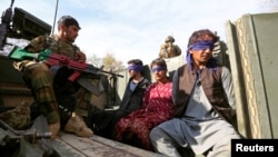 FILE - Taliban militants, who were arrested by Afghan security forces, sit on a vehicle during a presentation to the media, in Jalalabad, Afghanistan, March 17, 2018.