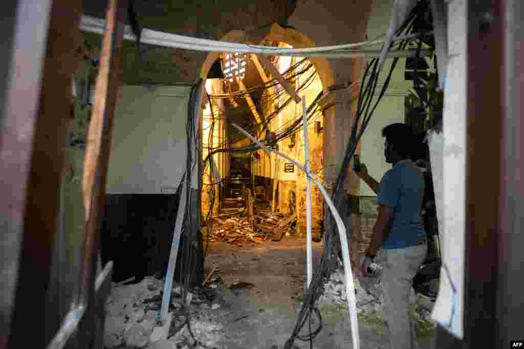 A Sri Lankan man uses his mobile phone to take pictures inside St. Anthony&#39;s Shrine in Colombo following a series of bomb blasts targeting churches and luxury hotels on Easter Sunday.