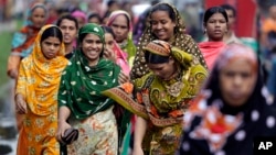 Bangladeshi garment workers arrive for work early morning in Dhaka, Bangladesh, Sept. 12, 2012. 