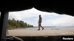 Ivorian soldier patrols town of Adiake, near their border with Ghana, Sept. 24, 2012.