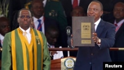 Kenya's President Uhuru Kenyatta displays his certificates of oath from Chief Justice Willy Mutunga during the swearing-in ceremony at Kasarani Stadium in Nairobi, Apr. 9, 2013.
