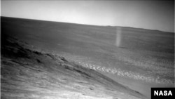 A dust devil is seen swirling across the Martian surface in this photo snapped by the Mars Opportunity rover.