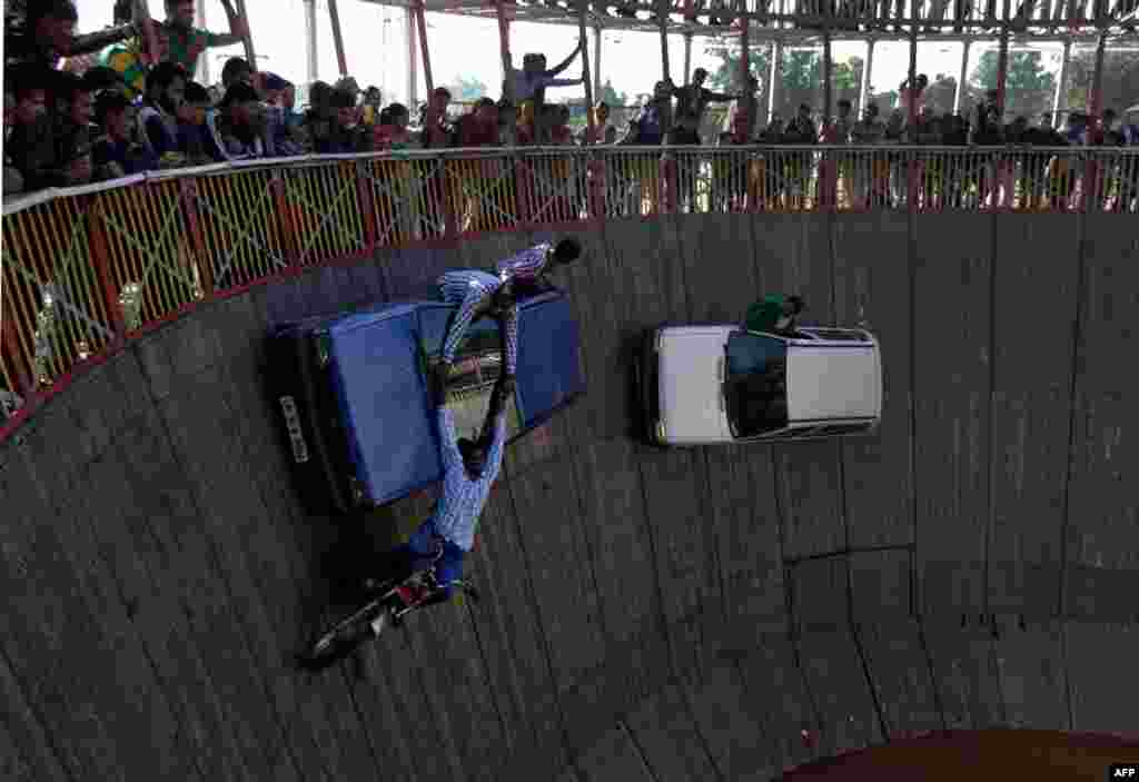 Indian performers ride cars and motor bikes inside a makeshift wooden cylindrical &#39;Wall of Death&#39; during the annual Farmers&#39; Fair at Shama Chak Jhiri, some 22 kilometers from Jammu. 
