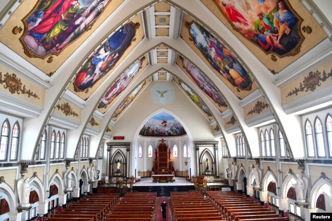 Seorang pria berjalan di dalam gereja yang lengang setelah pelarangan kegiatan dalam skala besar di tengah pandemi virus corona di Surabaya, Jawa Timur, 22 Maret 2020. (Foto: Antara Foto/Zabur Karuru/ via Reuters)