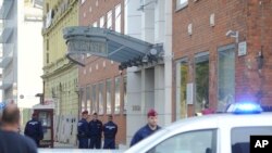 Police officers stand in front of the entrance of the Church of Scientology of Budapest headquarters in Vaci Road in Budapest, Hungary, Wednesday, Oct. 18, 2017.