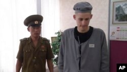 북한에 억류돼 6년 노동교화형을 선고받은 미국인 매튜 토트 밀러 씨(오른쪽)가 24일 가족과의 전화 통화를 위해 북환 교도관과 함께 평양의 한 호텔을 방문했다.