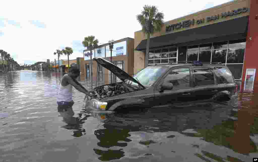 یکی از اهالی منطقه ای در فلوریدا سعی در روشن کردن اتومبیل خود پس از توفان دریایی ایرما دارد.