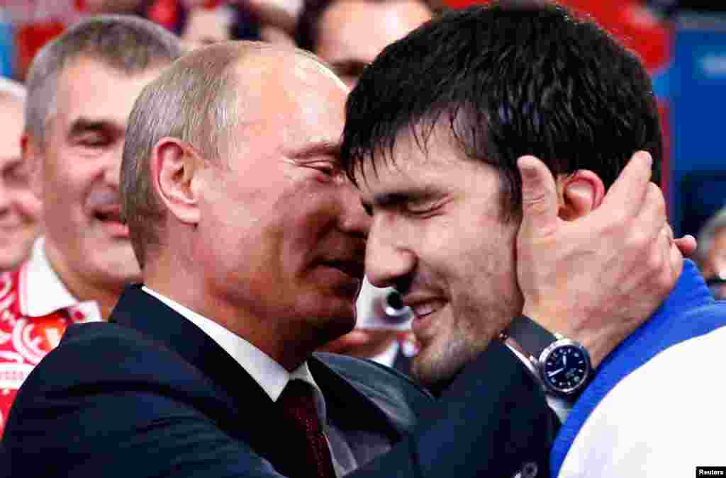 Russian President Vladimir Putin congratulates Russia's Tagir Khaibulaev after he defeated Mongolia's Tuvshinbayar Naidan in their men's -100kg final judo match.