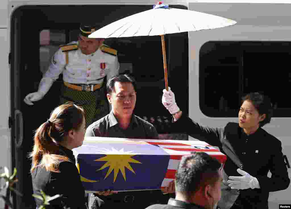 Lt Lee Vee Weng carries the remains of his one-year-old son Benjamin Lee Jian Han, who was killed in the MH17 crash, into the Xiao En Bereavement Centre in Kuala Lumpur, Sept. 9, 2014.