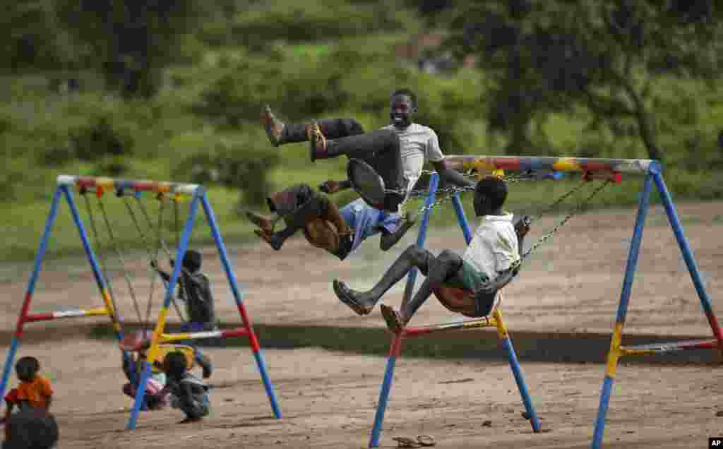 South Sudanese refugee children play on swings in the yard of the Ombechi nursery school in Bidi Bidi, Uganda.