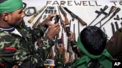 Militants of the Assam separatist group take photographs of arms displayed during a surrender ceremony in Guahati, India, January 24, 2012.