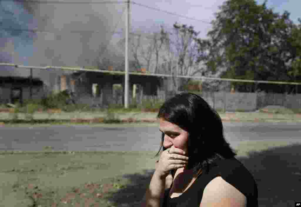 A local woman sits and cries in front of her burning house after shelling in Donetsk, eastern Ukraine, Sept. 7, 2014. 