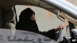 FILE - A woman drives a car on a highway in Riyadh, Saudi Arabia, as part of a campaign to defy Saudi Arabia's ban on women driving, March 29, 2014. Women's rights activists are among those being detained in Saudi Arabia. 