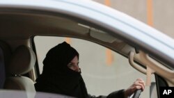 FILE - A woman drives a car on a highway in Riyadh, Saudi Arabia, as part of a campaign to defy Saudi Arabia's ban on women driving, March 29, 2014. Some female journalists remain in prison for reporting on increased freedoms for women.