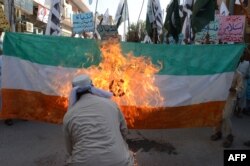 FILE - Pakistani activists of the Islamic organization Jamaat-ud-Dawa torch an Indian flag during a demonstration in Quetta, Oct. 10, 2014.
