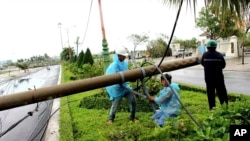 越南工人在中部富安省修理被台風“達維”吹倒的電線杆