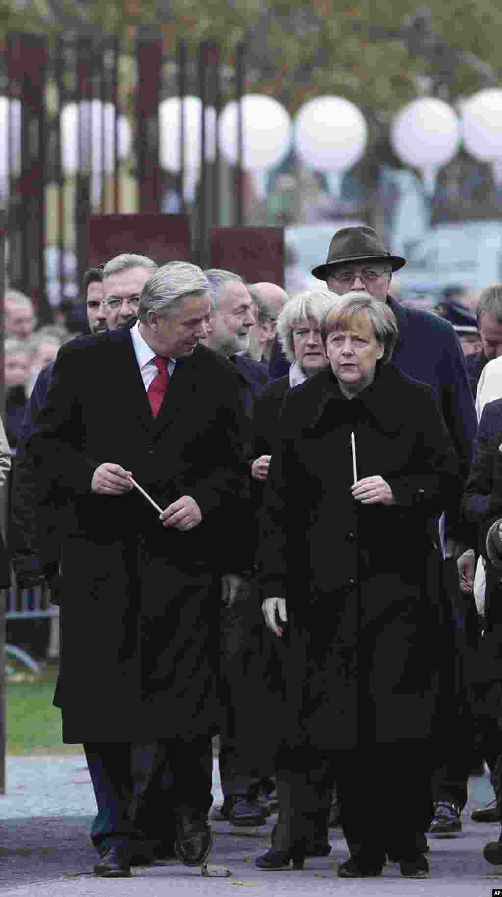 German Chancellor Angela Merkel, right, and Berlin's Mayor Klaus Wowereit, left, arrive for a candle ceremony to commemorate the victims of the wall at the Berlin Wall memorial site at Bernauer Strasse Berlin, Germany. 