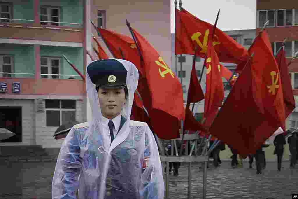 A North Korean traffic police woman directs vehicles at a street junction while behind her the sidewalk is decorated with flags of the ruling party, the Workers&#39; Party in Pyongyang, North Korea.
