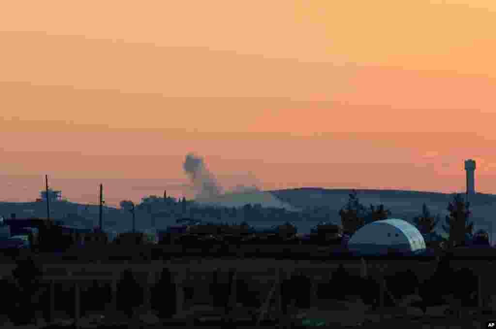 Smokes rise after a mortar shell landed in the west of Kobani, seen from the Turkish side of border as thousands of new Syrian refugees from Kobani arrive in Suruc, Turkey, Oct. 1, 2014. 