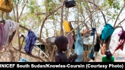 A young boy stands in front of the tree in a camp for the displaced in Mingkamen, where he and his family fled as violence raked the town of Bor in Jonglei state.