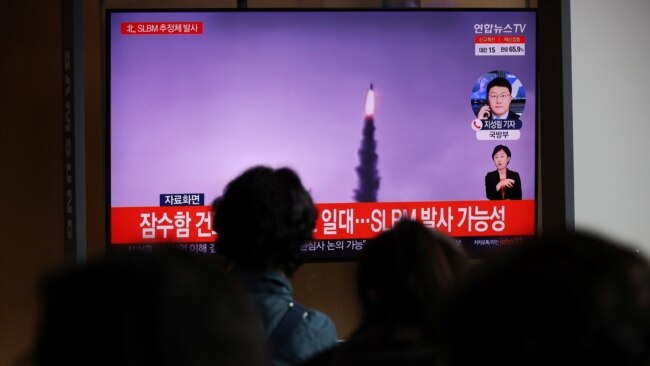 People watch a TV broadcasting file footage of a news report on North Korea firing a ballistic missile off its east coast, in Seoul, South Korea, October 19, 2021.