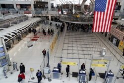 Passengers walk through Terminal 1, after further cases of coronavirus were confirmed in New York, at JFK International Airport in New York, U.S., March 13, 2020. REUTERS/Shannon Stapleton