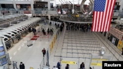 在美国纽约肯尼迪国际机场，乘客们走过1号航站楼（2020年3月13日）。