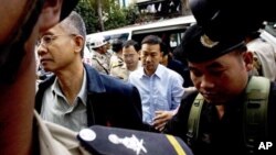 Thai activists Veera Somkwamkid, second left, a core leader of Yellow Shirts and Panich Vikitsreth, a member of Parliment of the ruling Democrat party, second right, are escorted by Cambodian court security personnel at Phnom Penh Municipal Court, file photo. 