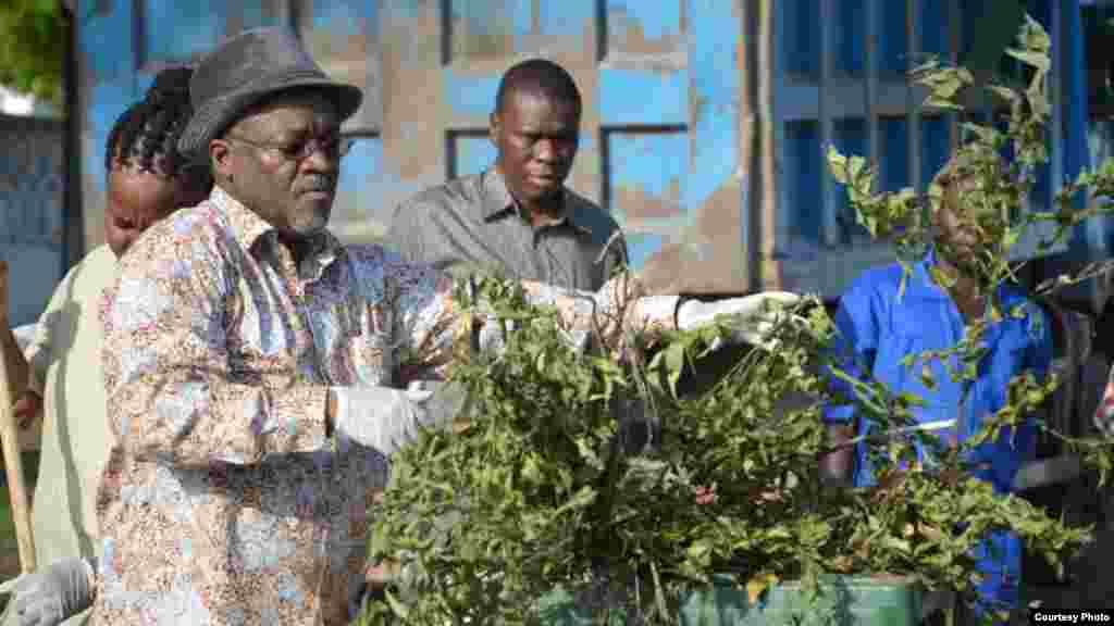 Le président tanzanien John Magufuli met des ordures dans une poubelle lors de travaux collectifs de nettoyage en commémoration du 54e anniversaire de l&#39;indépendance du Tanganyika.