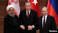 FILE - Presidents Hassan Rouhani of Iran, Recep Tayyip Erdogan of Turkey and Vladimir Putin of Russia hold a joint news conference after their meeting in Ankara, Turkey, April 4, 2018.