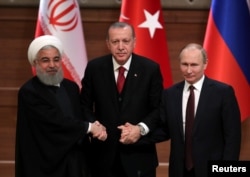 FILE - Presidents Hassan Rouhani of Iran, Recep Tayyip Erdogan of Turkey and Vladimir Putin of Russia gather at a news conference after their meeting in Ankara, Turkey, April 4, 2018.