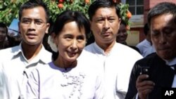 ေဒၚေအာင္ဆန္းစုၾကည္ႏွင့္အဖြဲ႕ ရန္ကုန္တုိင္း တရား႐ုံးခ်ဳပ္တြင္ က်မ္းက်ိန္လႊာ ျပဳလုပ္ၿပီးေနာက္ ျပန္လည္ထြက္ခြာလာစဥ္။ ႏုိ၀င္ဘာ ၁၆၊ ၂၀၁၀။