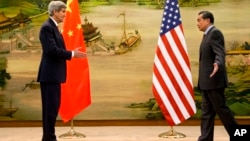 U.S. Secretary of State John Kerry, left, and Chinese Foreign Minister Wang Yi approach to shake hands after attending a news conference at the Ministry of Foreign Affairs in Beijing, Jan. 27, 2016. 