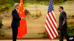 중국을 방문한 존 케리 미국 국무장관(왼쪽)과 왕이 중국 외교부장이 27일 베이징에서 공동기자회견을 가진 후 악수하기 위해 마주보고 있다.