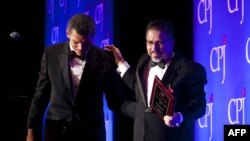 FILE - Mexican journalist Javier Valdez Cardenas (R) walks off stage after accepting the 2011 International Press Freedom award in New York, Nov. 22, 2011.