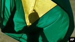 Un soldat déploie le drapeau brésilien lors de la cérémonie de levée du drapeau au palais Alvorada, à Brasilia, au Brésil. (AP Photo /Eraldo Peres)
