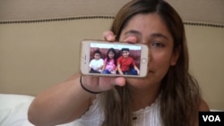 FILE - Yeni Gonzalez shows a photo of her children.