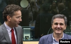 Newly appointed Greek Finance Minister Euclid Tsakalotos (R) is welcomed by Eurogroup President Jeroen Dijsselbloem (L) at a euro zone finance ministers meeting on the situation in Greece in Brussels, Belgium, July 7, 2015.