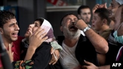 Palestinian mourners cry at Gaza City's al-Shifa hospital after an explosion killed at least seven children in a public playground in the beachfront Shati refugee camp on July 28, 2014.