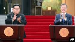 រូបឯកសារ៖ មេដឹកនាំកូរ៉េខាងជើងលោក Kim Jong Un (ខាងឆ្វេង) និង​ប្រធានាធិបតីកូរ៉េខាងត្បូងលោក Moon Jae-in ទះដៃអបអរសាទរ​ការ​ចេញសេចក្តីប្រកាស​រួម​នៅ​ភូមិ Panmunjom ជាប់​ព្រំដែន ប្រទេសកូរ៉េទាំងពីរ កាល​ពី​ថ្ងៃ​សុក្រ ទី២៧ ខែមេសា ឆ្នាំ​២០១៨។ 
