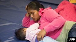 Una mujer guatemalteca y su pequeña hija que buscan asilo pasan el tiempo en un centro de ayuda de Catholic Charities, en Texas. 