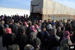 In this photo provided by Turkey's Islamic aid group of IHH, Syrians fleeing the conflicts in Azaz region, congregate at the Bab al-Salam border gate, Syria, Feb. 5, 2016.