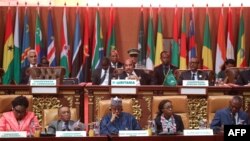 FILE - Mauritanian President Mohamed Ould Abdel Aziz, Rwandan President Paul Kagame and African Union Commission Secretary-General Mourad Ben Dhiab sit with delegates at the plenary session of the 31st Ordinary Session of the Assembly of African Union (AU) Heads of State and Government in Nouakchott, Mauritania, July 1, 2018.