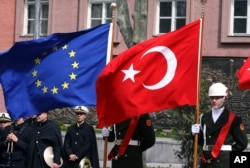 FILE - Members of a Turkish honor guard hold an EU flag and a Turkish flag in Ankara, Turkey, April 10, 2008.