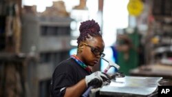 Carey Mercer tampak menyusun sebuah rancangan saluran udara di tempat ia bekerja Contractors Sheet Metal di New York, pada 3 Agustus 2021. Industri konstruksi di AS masih kesulitan meraup lebih banyak tenaga kerja perempuan. (Foto: AP/Kevin Hagen)