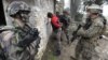 FILE - Soldiers of the Special Purpose Marine Air-Ground Task Force (SPMAGTF) and soldiers of the French 21st Marine Infantry Regiment arrest the acting terrorist "Geronimo" as they take part in a Franco-American military exercise called "Garrigues Fury 2014" at military camp of Garrigues, near Nimes, southern France, Feb. 13, 2014. 